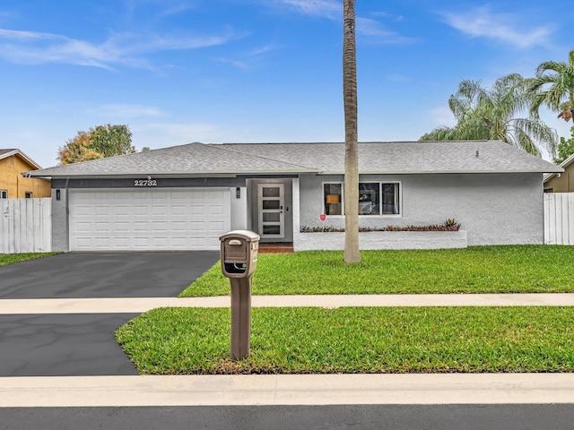 ranch-style house featuring a front yard and a garage