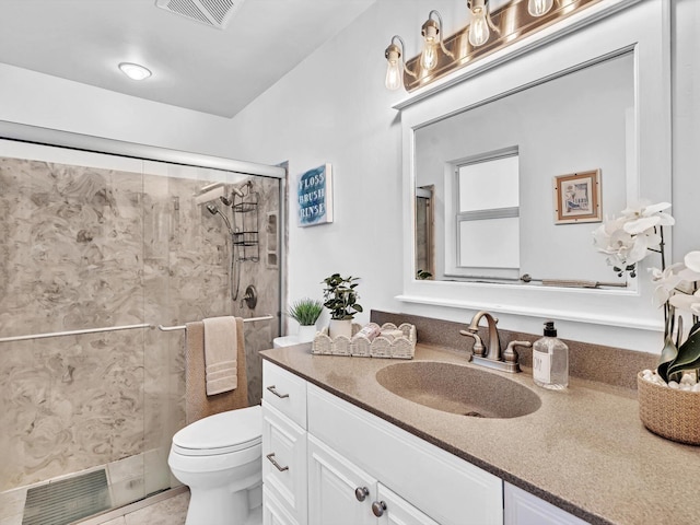 bathroom featuring toilet, tile patterned floors, a shower with shower door, and vanity