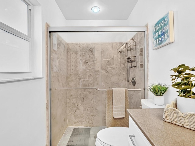 bathroom with an enclosed shower, vanity, and toilet