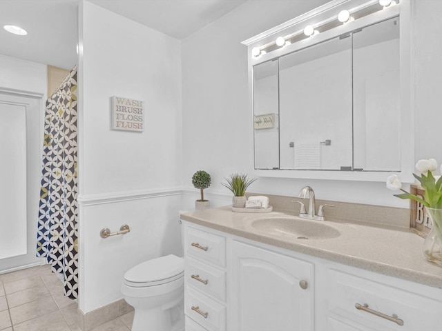 bathroom featuring toilet, vanity, and tile patterned flooring