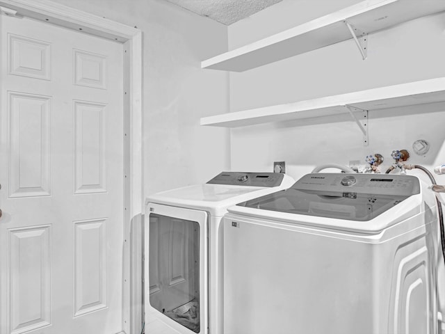 laundry room with a textured ceiling and independent washer and dryer