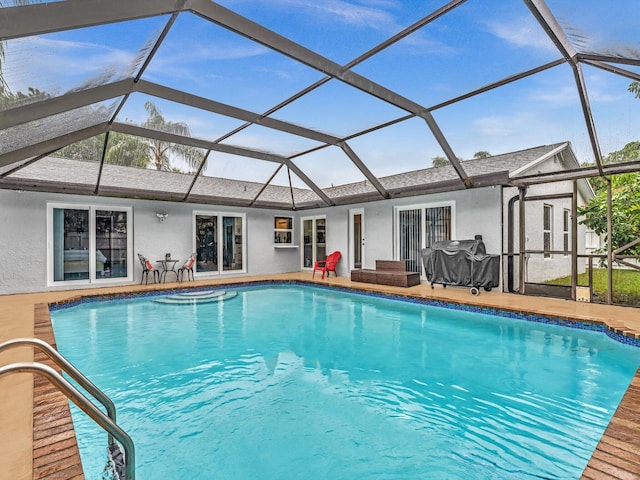 view of pool with a lanai, a grill, and a patio area