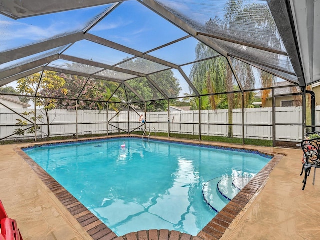 view of pool with glass enclosure and a patio