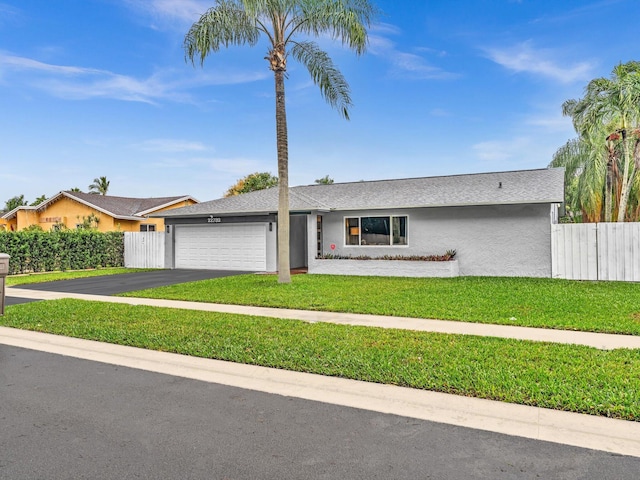 ranch-style house featuring a front yard and a garage