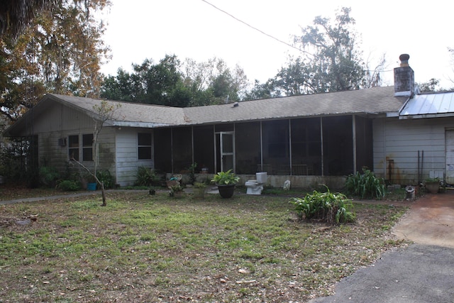 back of property featuring a sunroom and a yard