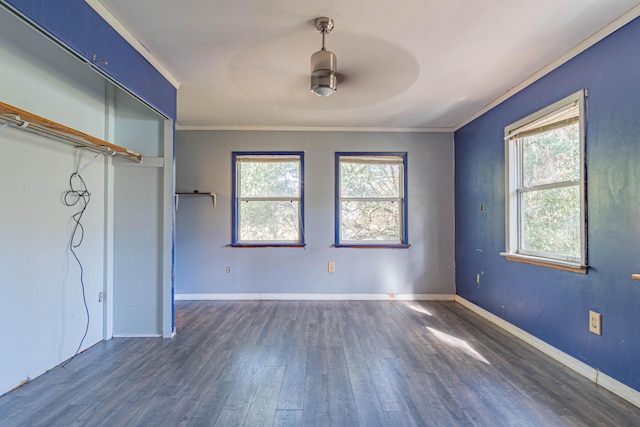 empty room featuring crown molding, dark hardwood / wood-style floors, and a healthy amount of sunlight