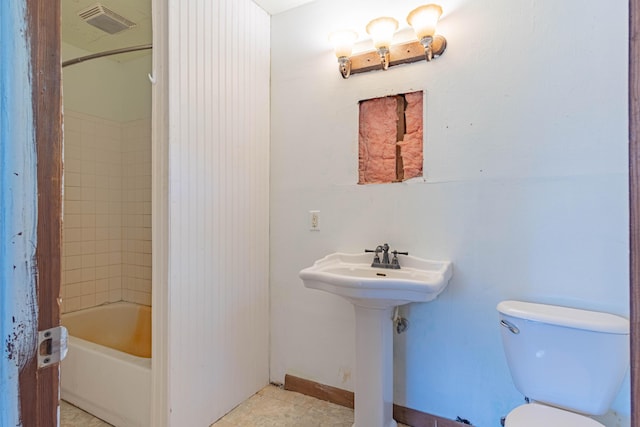 bathroom with tile patterned floors, toilet, and tiled shower / bath