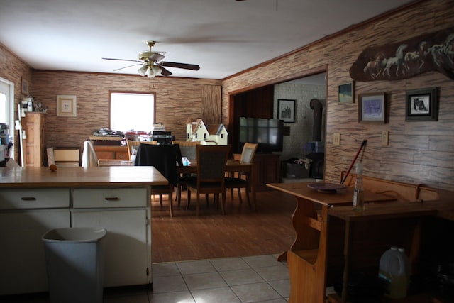 tiled dining area featuring ceiling fan and crown molding