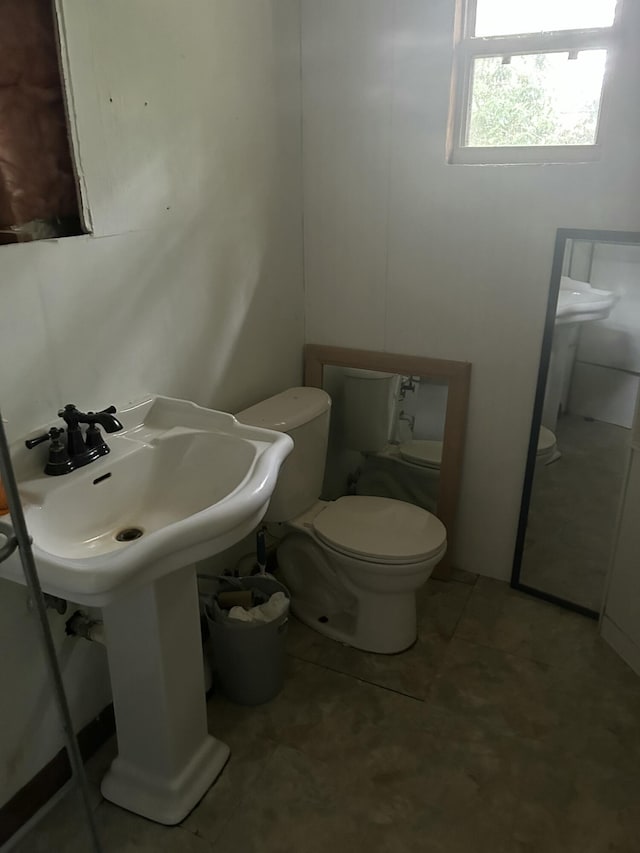 bathroom with toilet and tile patterned flooring