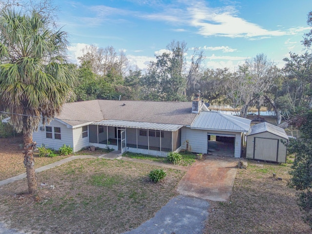 ranch-style home with a shed, a sunroom, and a carport