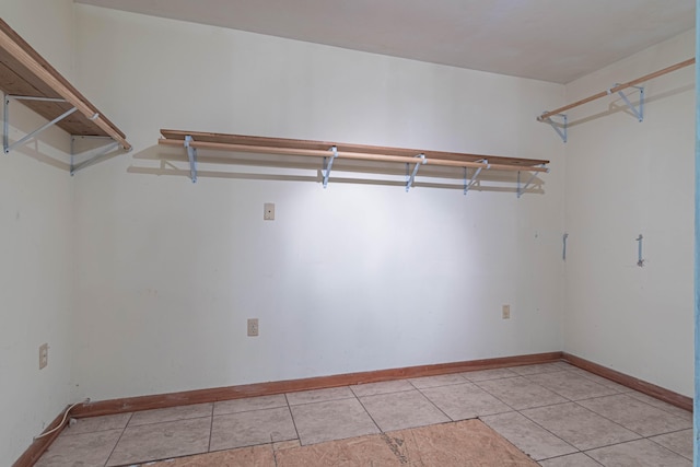 walk in closet with light tile patterned floors