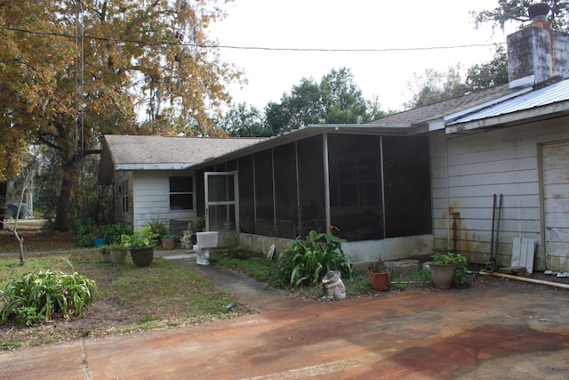 back of property with a patio area and a sunroom