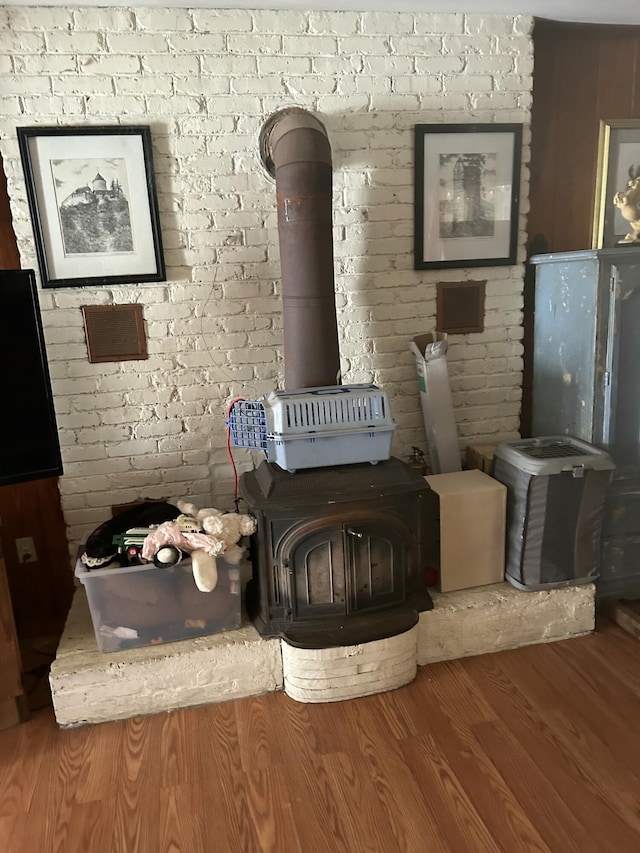 room details featuring a wood stove and wood-type flooring