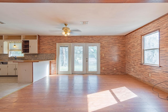 kitchen featuring white cabinets, ceiling fan, light hardwood / wood-style floors, backsplash, and sink