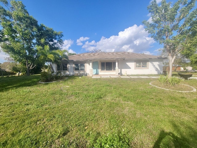 rear view of house featuring a lawn