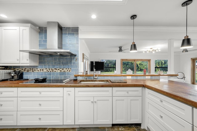 kitchen featuring decorative light fixtures, white cabinets, decorative backsplash, black electric cooktop, and wall chimney exhaust hood