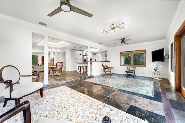 living room featuring ornamental molding, plenty of natural light, and ceiling fan with notable chandelier