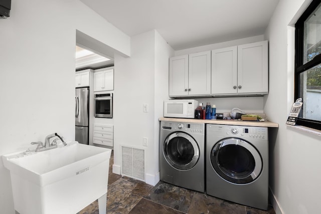 laundry area featuring cabinets, sink, and washing machine and dryer