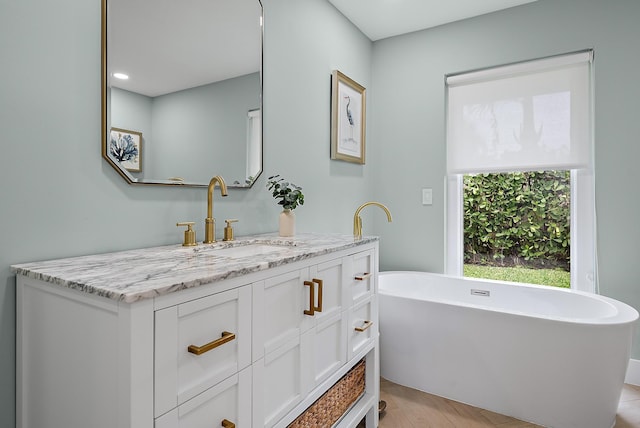 bathroom with a tub to relax in and vanity