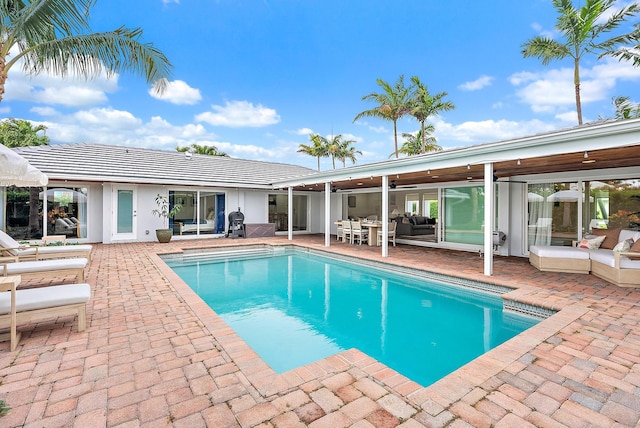 view of pool featuring ceiling fan, an outdoor living space, and a patio