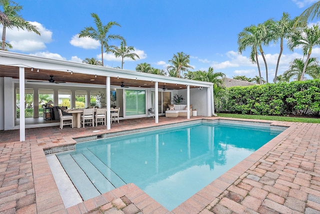 view of swimming pool with ceiling fan and a patio