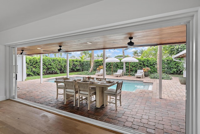 view of patio with ceiling fan and a fenced in pool