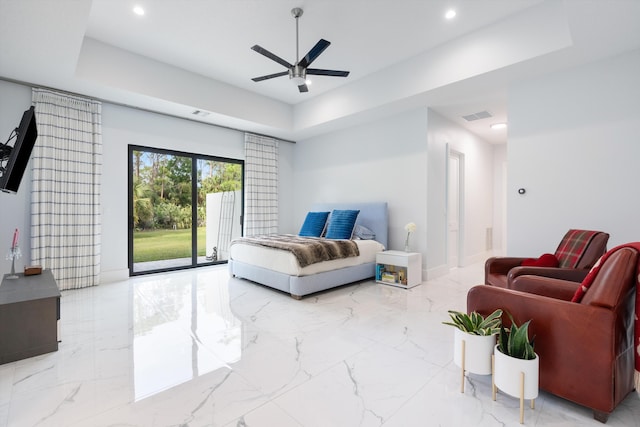 living room with a raised ceiling and ceiling fan