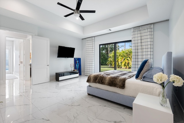 bedroom featuring access to exterior, a tray ceiling, and ceiling fan