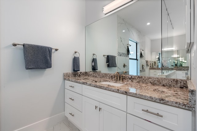 bathroom featuring vanity and tiled shower