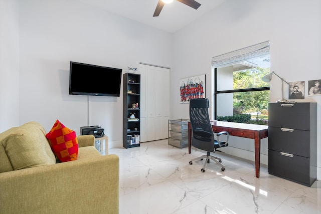 office featuring a towering ceiling and ceiling fan