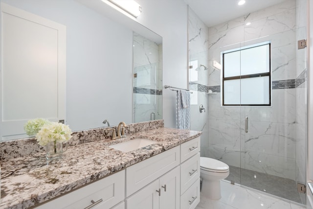 bathroom featuring vanity, toilet, and a shower with door