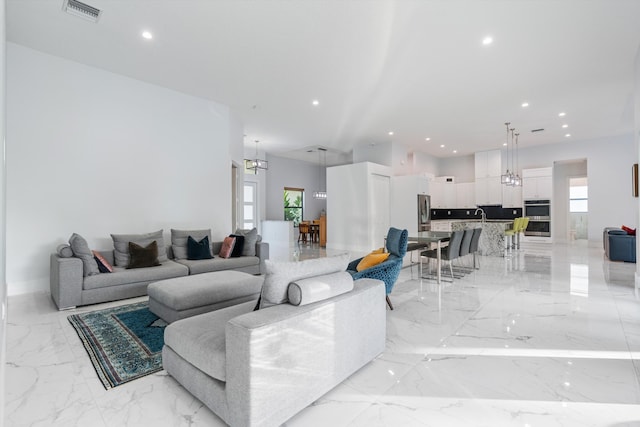 living room with sink, a notable chandelier, and a healthy amount of sunlight