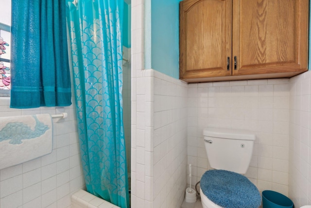 bathroom featuring toilet, tile walls, and curtained shower