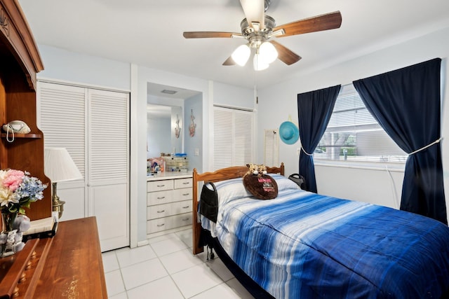 tiled bedroom with multiple closets and ceiling fan