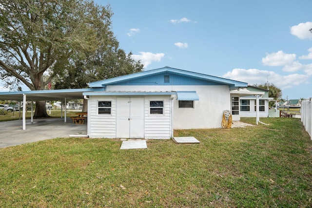 back of property featuring a lawn and a storage unit