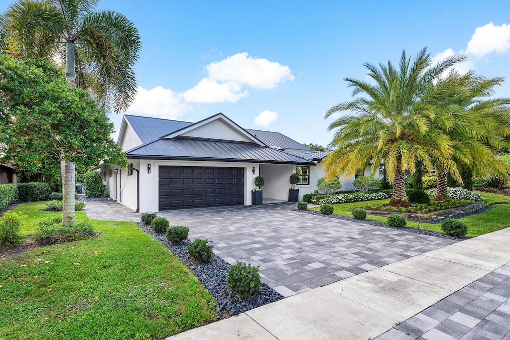 view of front of property with a front yard and a garage