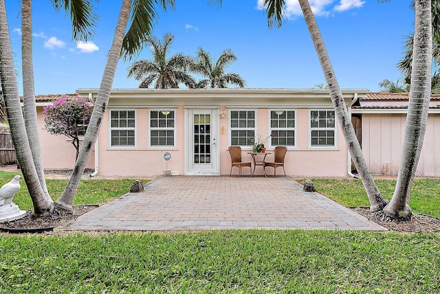 rear view of house with a patio area and a lawn