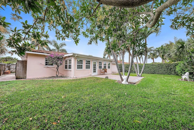 back of property with a lawn, a fenced backyard, a patio, and stucco siding