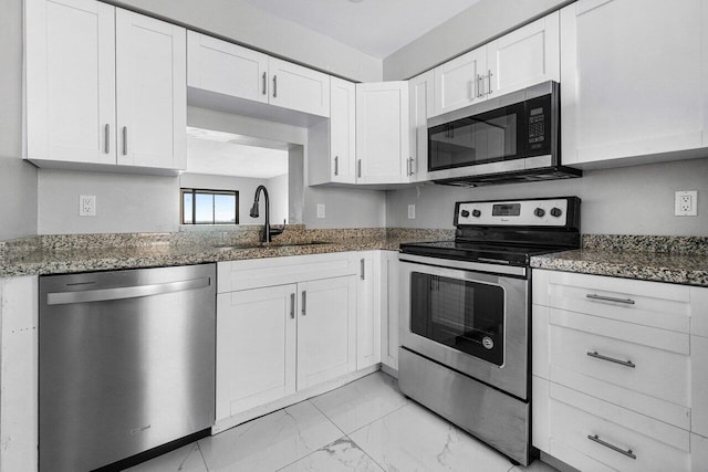 kitchen with stainless steel appliances, sink, dark stone counters, and white cabinets