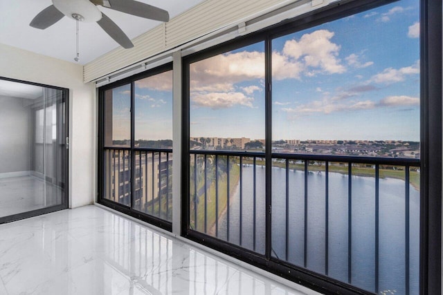 unfurnished sunroom featuring a water view, plenty of natural light, and ceiling fan