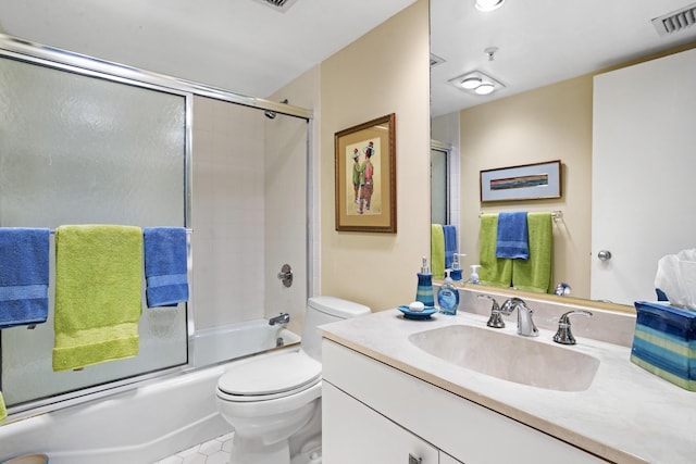 full bathroom with vanity, tile patterned floors, combined bath / shower with glass door, and toilet