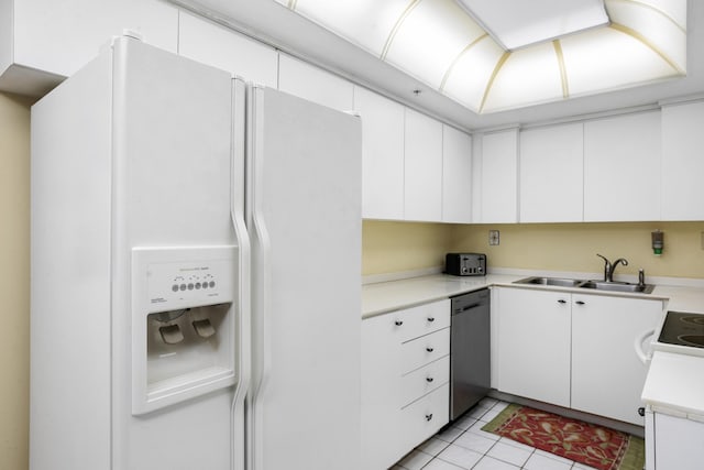 kitchen featuring sink, light tile patterned floors, white refrigerator with ice dispenser, white cabinets, and stainless steel dishwasher