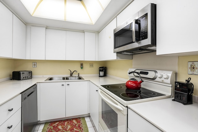 kitchen featuring white cabinets, dishwasher, sink, and electric range