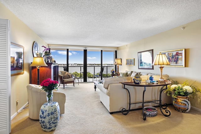 living room featuring light colored carpet, a textured ceiling, and a wall of windows