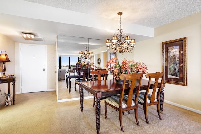 dining room with light colored carpet, a notable chandelier, and a textured ceiling