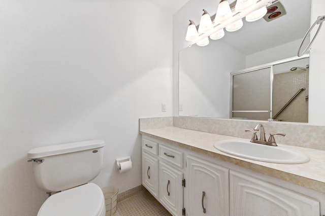 bathroom with a shower with shower door, toilet, vanity, and tile patterned flooring