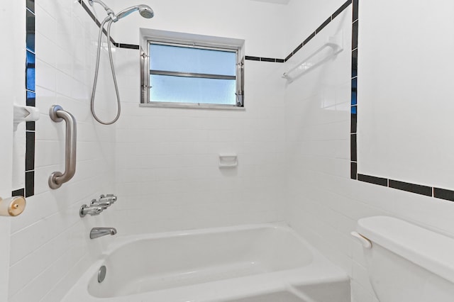 bathroom with toilet, tile walls, and tiled shower / bath combo