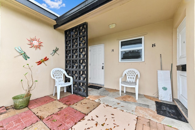 view of exterior entry with a patio area