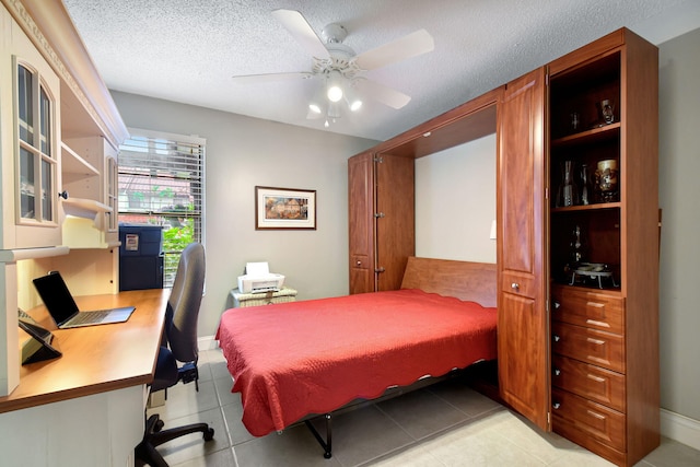 bedroom featuring a textured ceiling, ceiling fan, and light tile patterned flooring