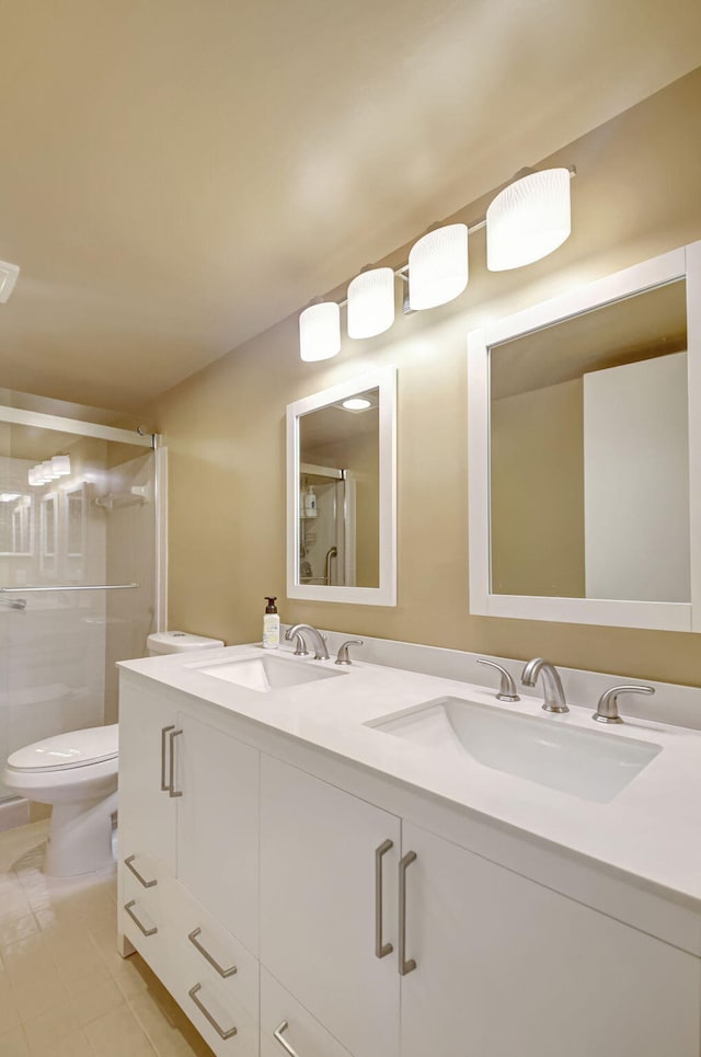 bathroom with vanity, toilet, a shower with shower door, and tile patterned flooring